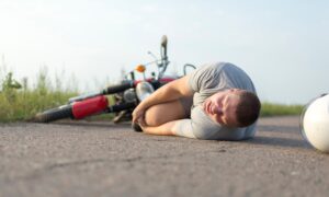 A man lays on the floor after being involved in a bike accident.