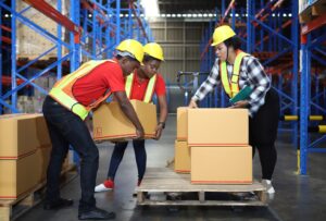 Workers carrying out manual handling tasks in a warehouse.