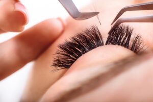 A close up shot of eyelash extensions being fitted on a woman's eye. 