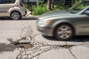 A car is about to hit a pothole. 