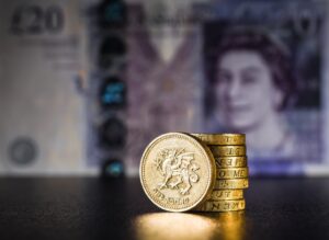 A pile of £1 coins in front of a £20 note to represent broken ribs compensation. 