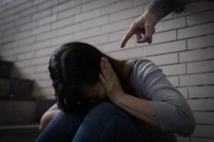 A woman who has suffered domestic violence sits on the stairs.