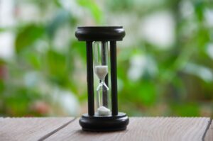 A sand timer sitting on a table outside to represent the accident at work claims time limit.