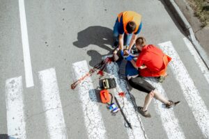 A pedestrian hit by a car is lying injured on a zebra crossing.