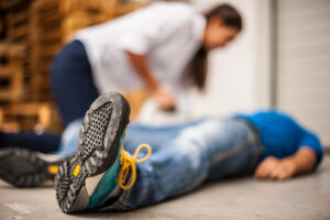 A woman provides first aid to an injured worker.