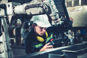 A factory worker uses machinery.